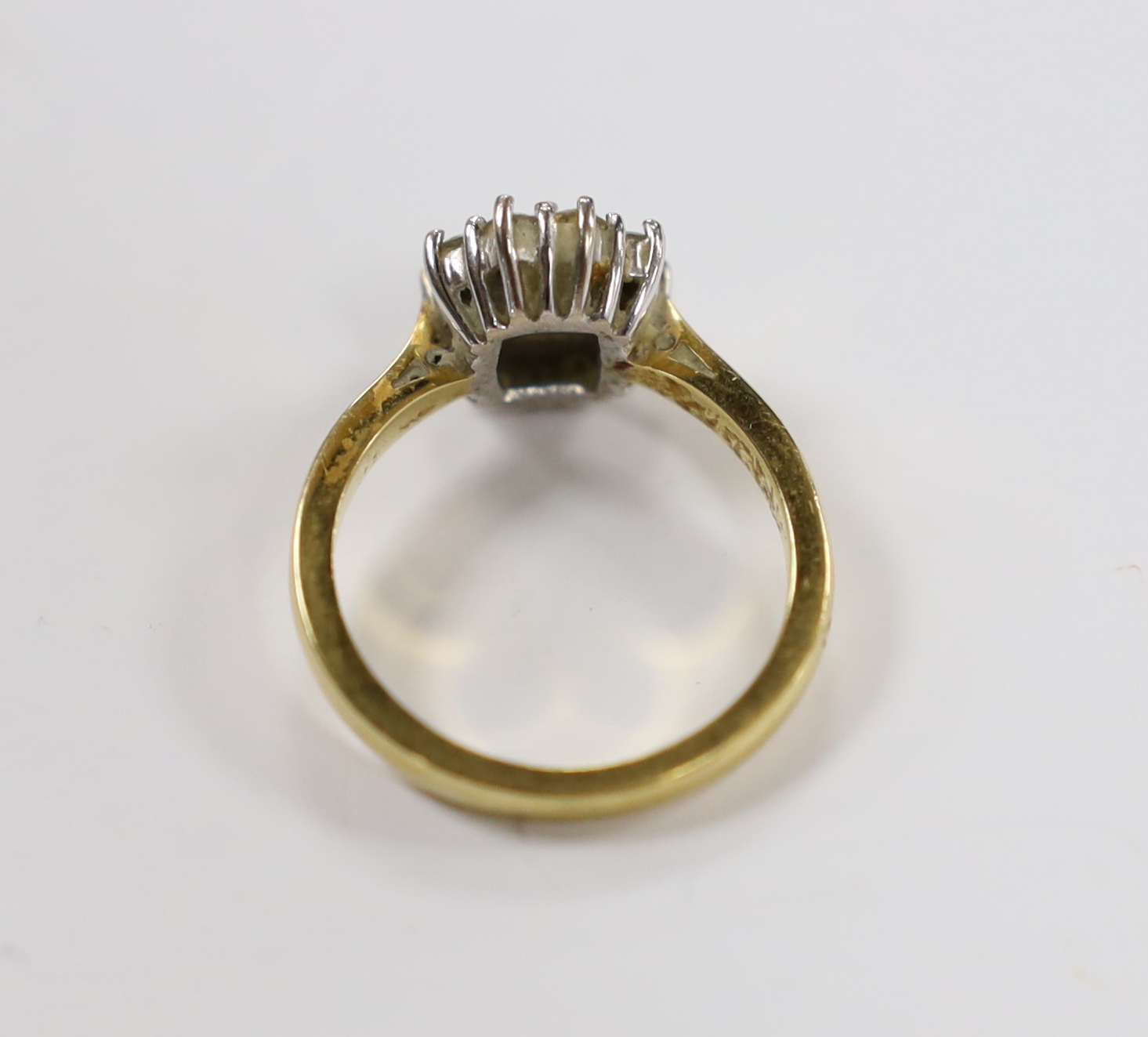 A modern 18ct gold, emerald and diamond set oval cluster ring, size L/M, gross weight 4.9 grams.